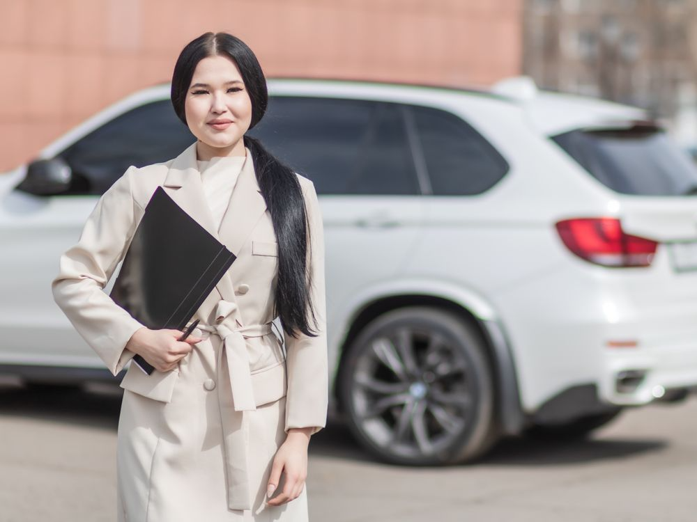 Professional holding folder with vehicle in background during claim process