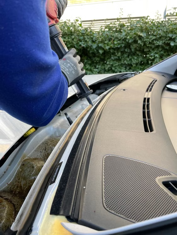 Technician replacing car windshield during auto glass service